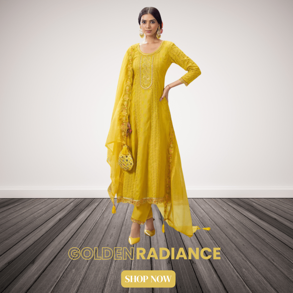 Woman wearing a bright yellow embroidered Anarkali suit with matching pants and dupatta, holding a traditional potli bag, standing on a wooden floor with a light beige background. Text on image reads "GOLDEN RADIANCE" and "SHOP NOW"