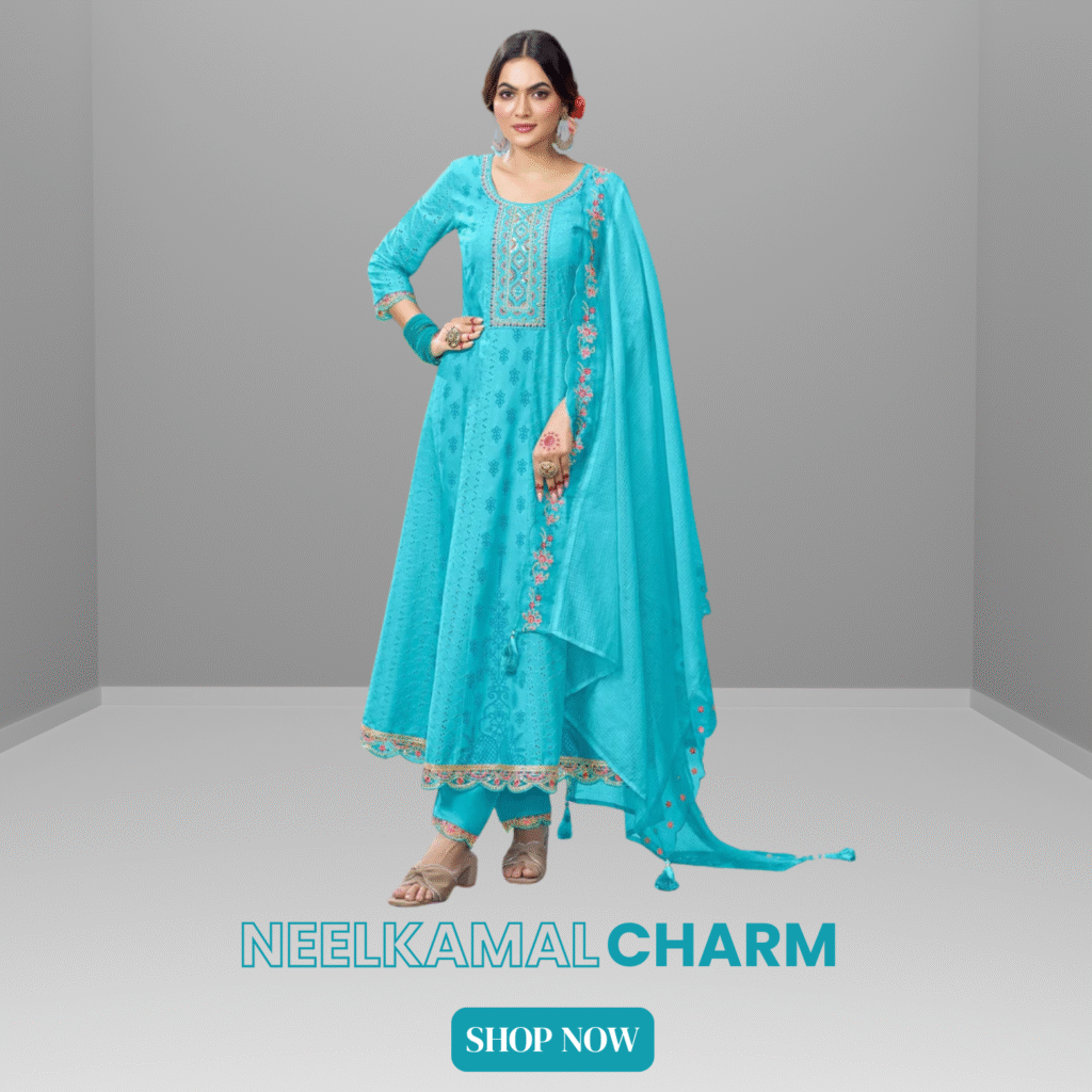 Woman wearing a bright turquoise blue Anarkali suit with floral embroidery, paired with matching pants and dupatta, standing in a minimalist grey corner studio. Text on the image reads "NEELKAMAL CHARM" and "SHOP NOW"