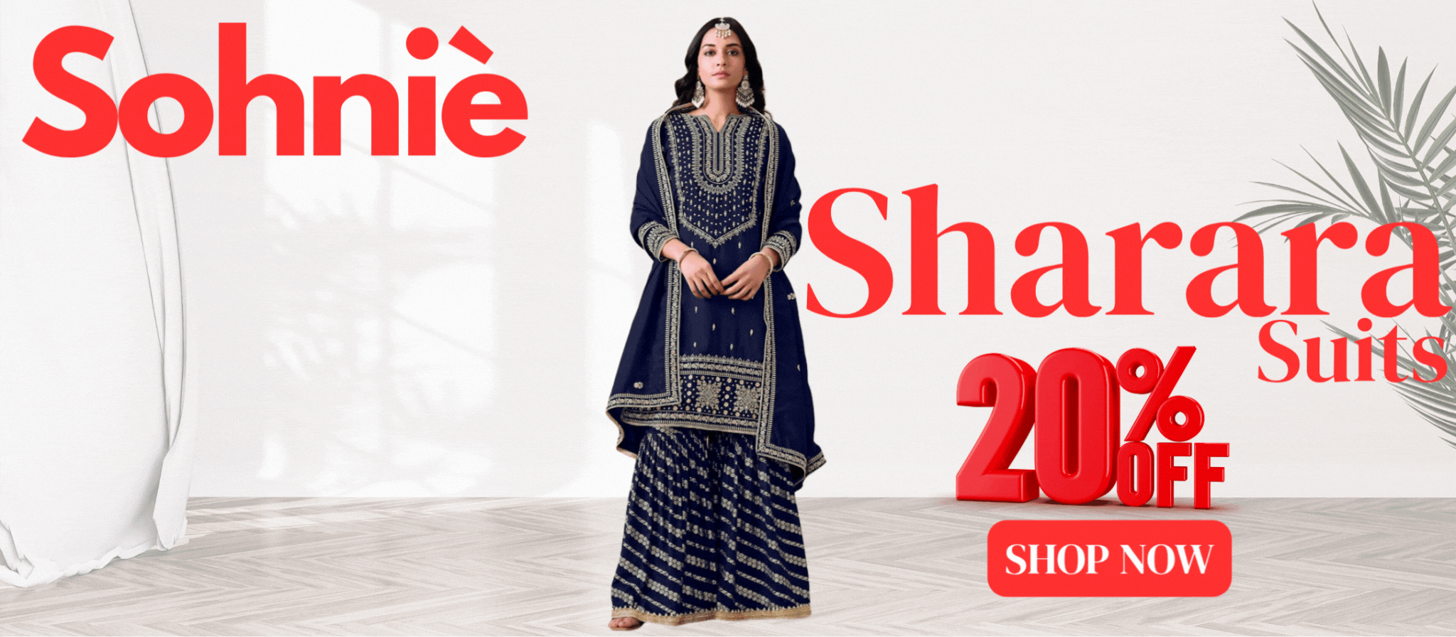 Promotional banner for Sohniè showcasing a woman in a navy blue embroidered sharara suit. The banner highlights a 20% OFF offer on Sharara Suits with a red "SHOP NOW" button. The background features minimalistic white decor with plant shadows and elegant floor patterns.